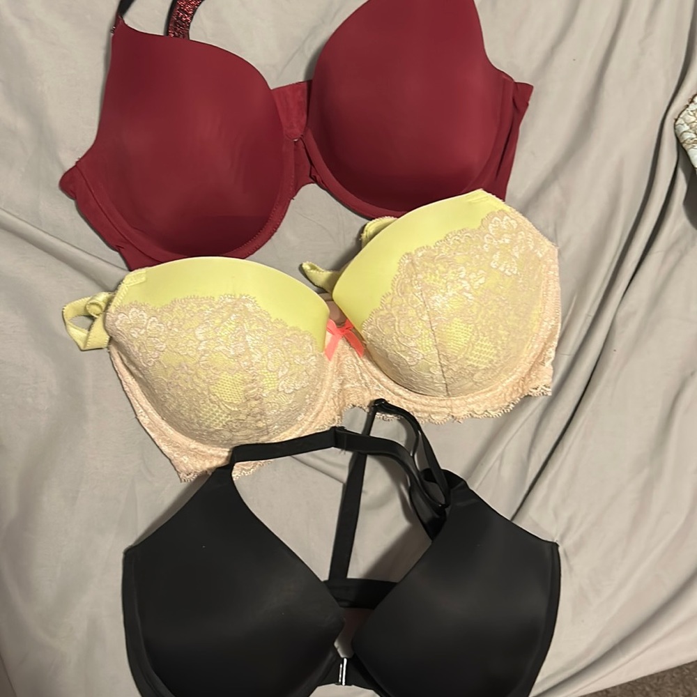 Three Pink Victoria Secret bras. Maroon. Lime green. Black push up.